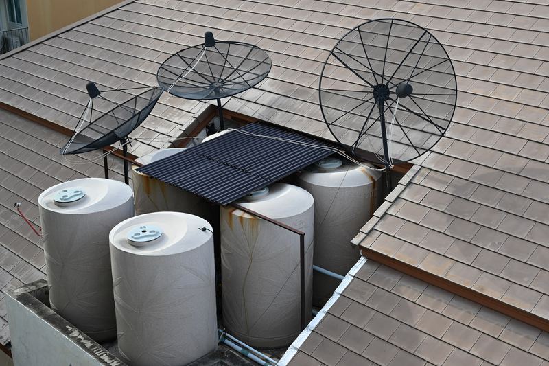 DZ6 2947 Rooftop view in Pattaya water storage tanks and satellite dishes tucked into a tiled roof cavity